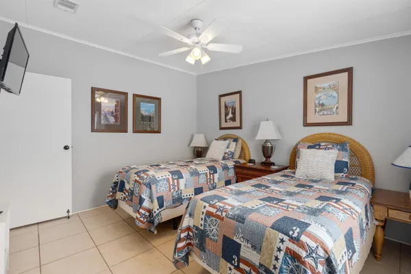 a bedroom with two beds and a chandelier