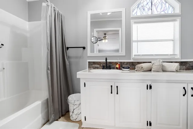 a bathroom with a bathtub sink and mirror