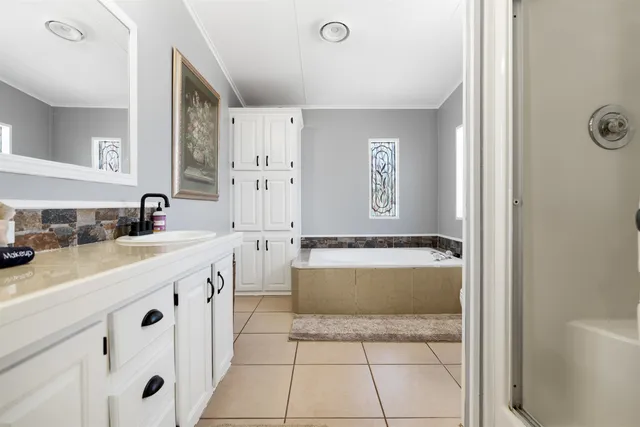 a bathroom with a tub a sink and a mirror