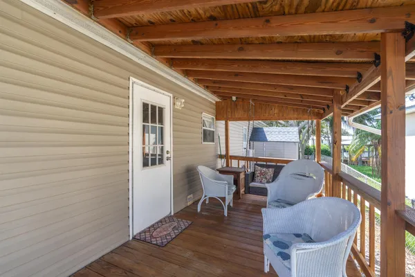 a view of a porch with furniture and a yard