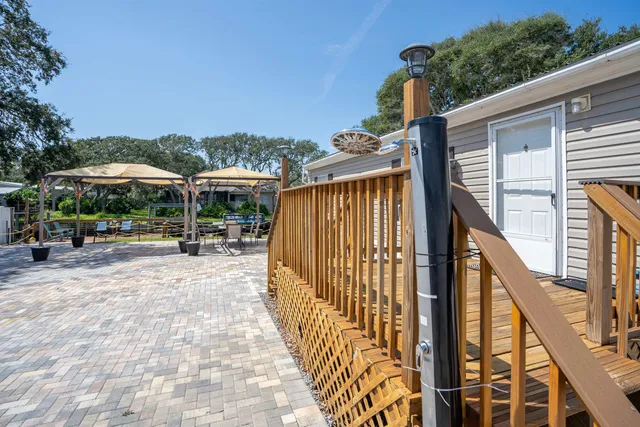 a view of a patio with a table and chairs under an umbrella with wooden fence