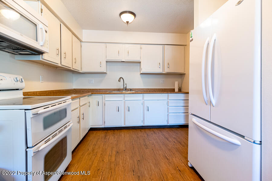 341 Clarkson Avenue Rifle, CO 81650 - Photo 11 of 16 a kitchen with white cabinets and white appliances