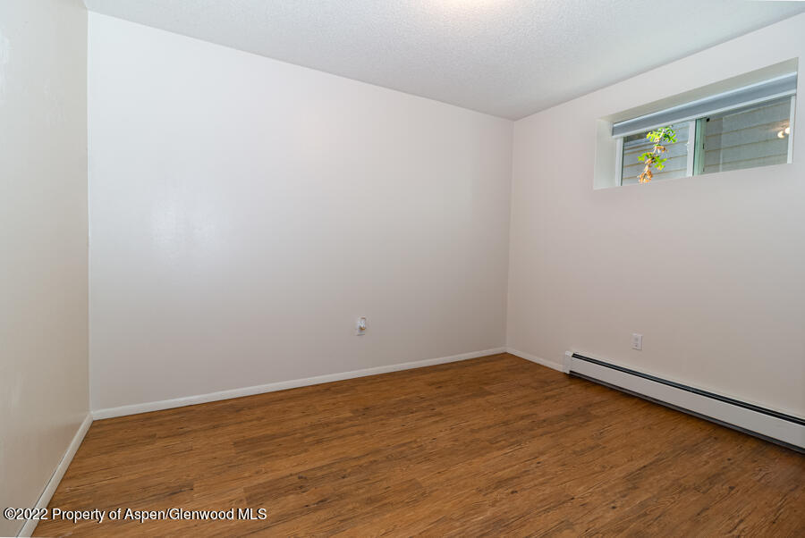 341 Clarkson Avenue Rifle, CO 81650 - Photo 13 of 16 a view of an empty room with wooden floor and a window