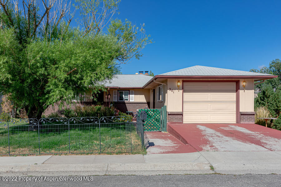 341 Clarkson Avenue Rifle, CO 81650 - Photo 2 of 16 a front view of a house with a yard and potted plants