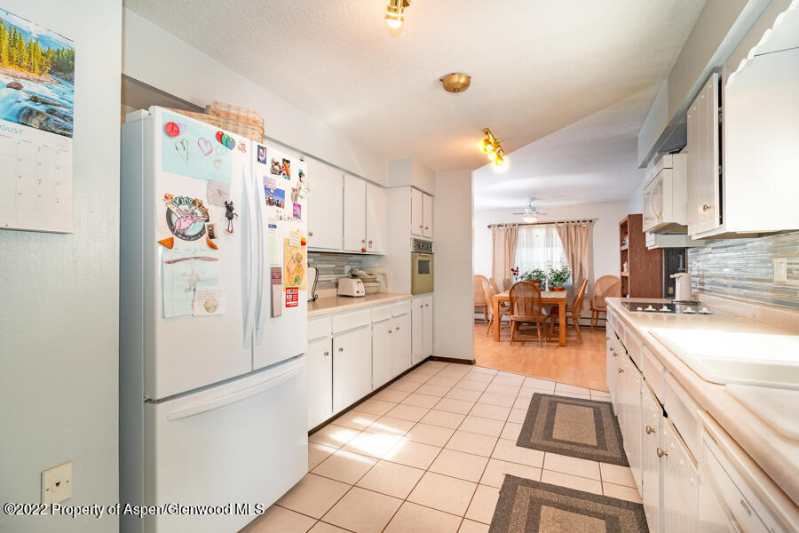 341 Clarkson Avenue Rifle, CO 81650 - Photo 5 of 16 a kitchen with a sink a refrigerator and cabinets