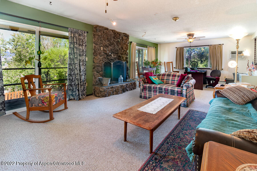341 Clarkson Avenue Rifle, CO 81650 - Photo 6 of 16 a living room with furniture a rug and a floor to ceiling window