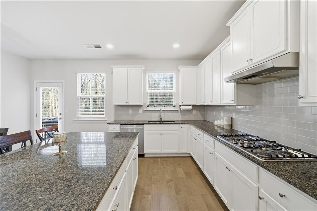 175 Paxton Lane Jefferson, GA 30549 - Photo 11 of 39 a large kitchen with stainless steel appliances granite countertop a stove top oven a sink a dining table and chairs
