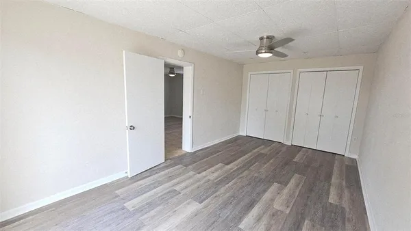 a view of an empty room with wooden floor