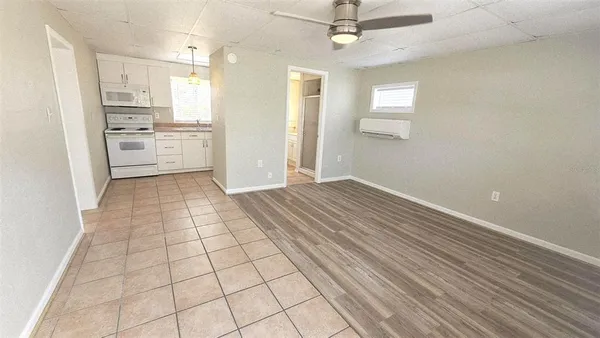 an empty room with wooden floor cabinet and windows