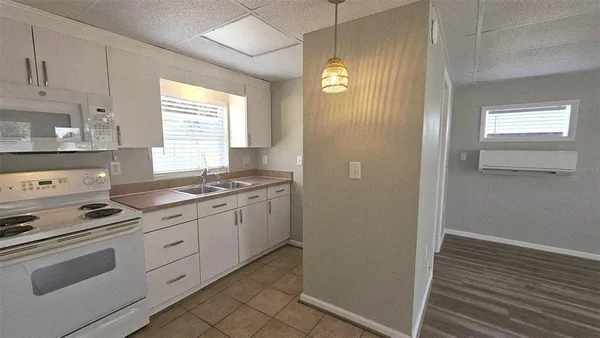 a kitchen with granite countertop white cabinets and white appliances