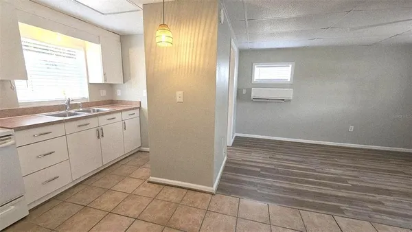 a view of a kitchen with wooden floor and cabinets
