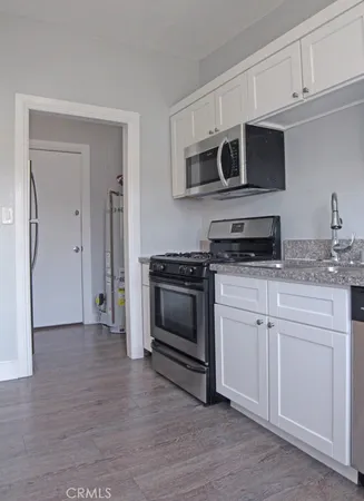 a kitchen with stainless steel appliances granite countertop a sink stove and microwave