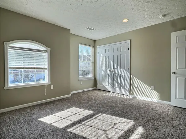a view of an empty room with window and bathroom