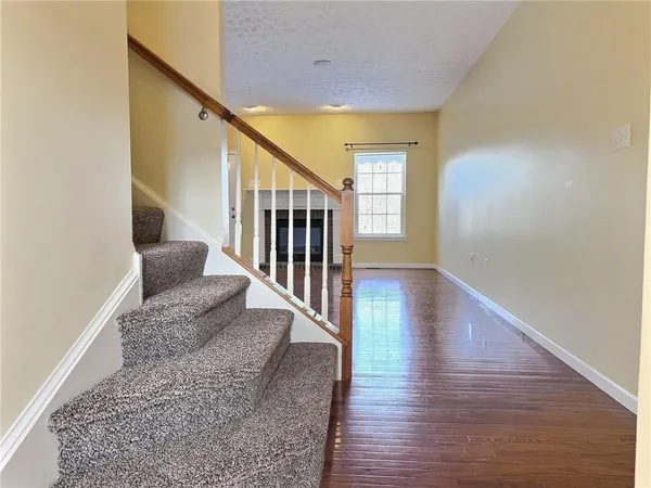 a view of entryway and hall with wooden floor