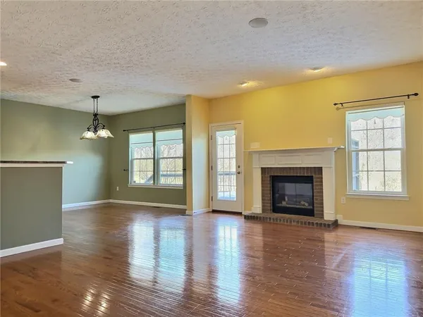 a view of empty room with wooden floor and fireplace