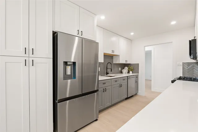 a kitchen with stainless steel appliances a sink stove and cabinets