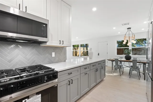 a kitchen with a stove and white cabinets