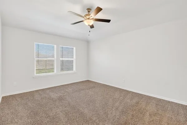 an empty room with a window and a ceiling fan