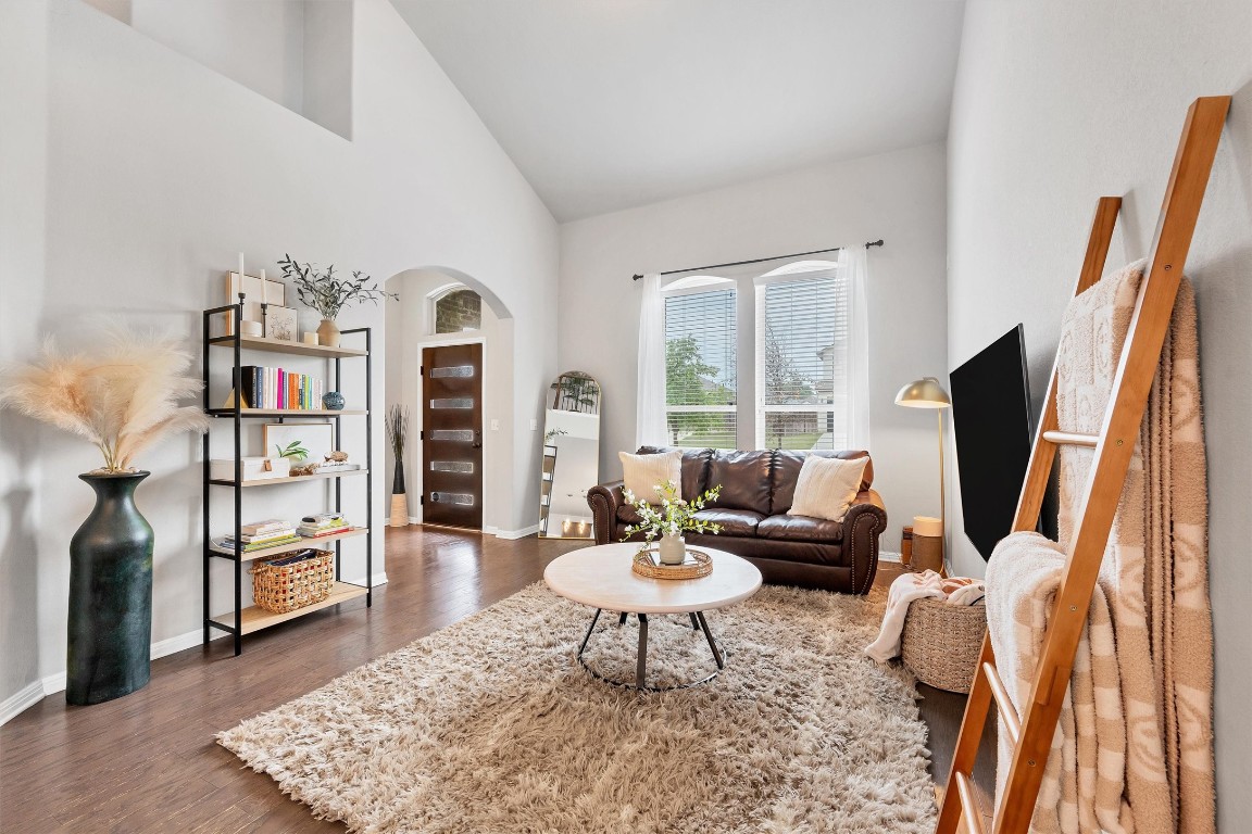 Step into the bright and airy living room, adorned with tall ceilings and exquisite flooring,