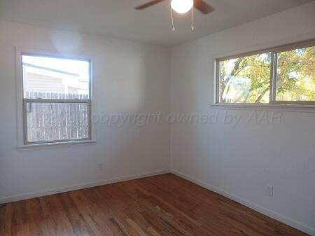 4416 South Hayden Street Amarillo, TX 79110 - Photo 6 of 15 an empty room with wooden floor and windows