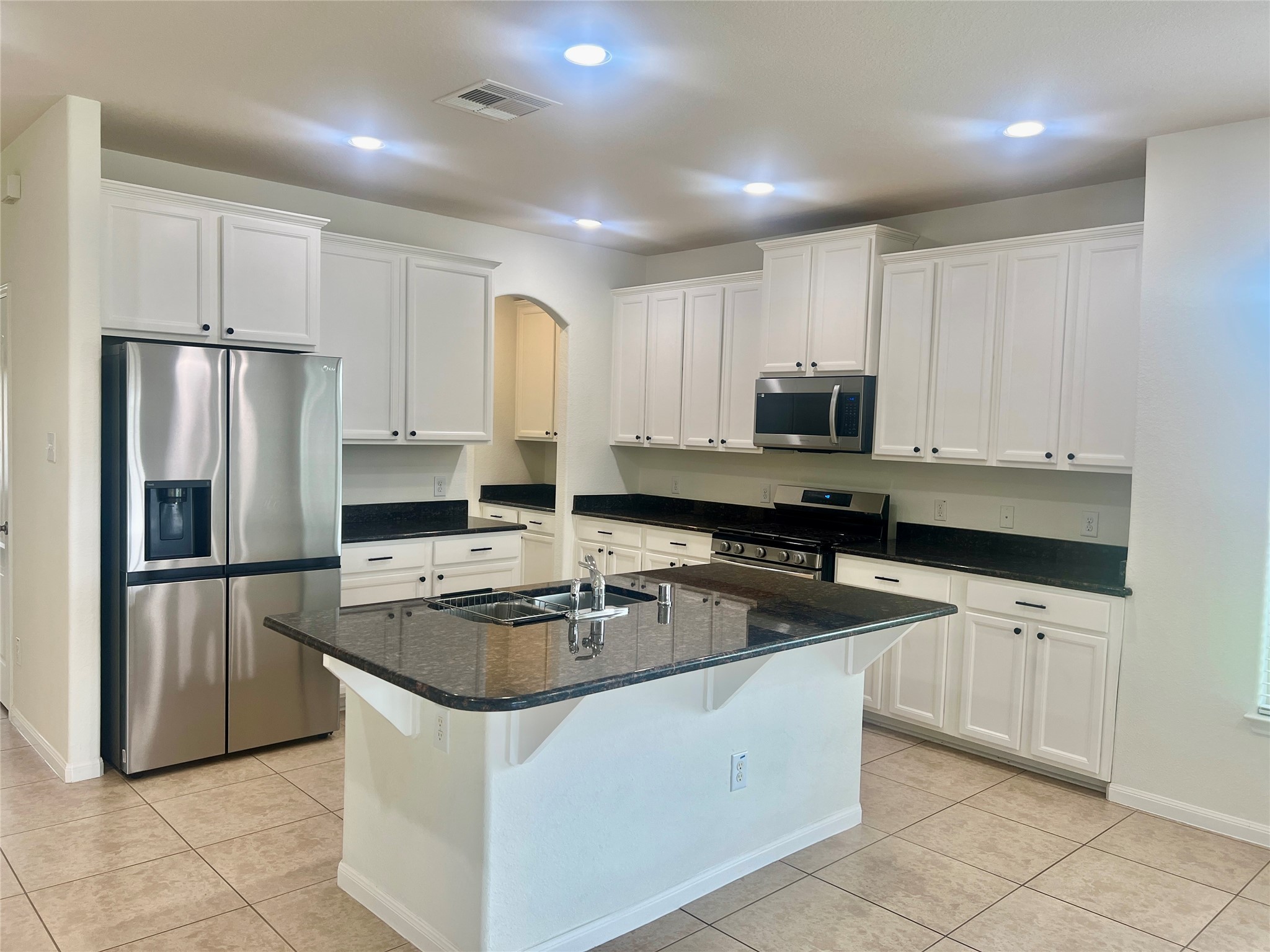 25307 Holton Ridge Drive Katy, TX 77494 - Photo 13 of 26 a kitchen with granite countertop a refrigerator sink and microwave