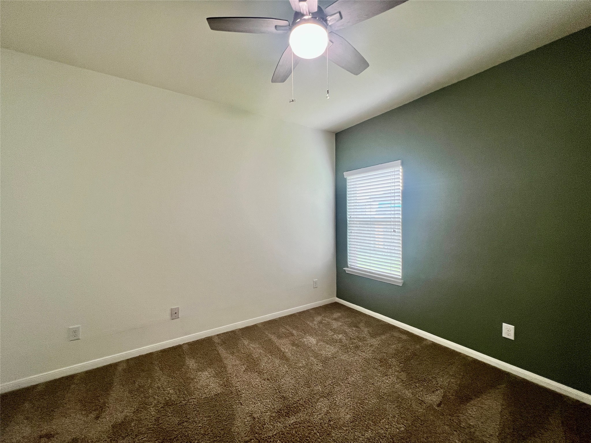 25307 Holton Ridge Drive Katy, TX 77494 - Photo 21 of 26 an empty room with a chandelier fan and windows