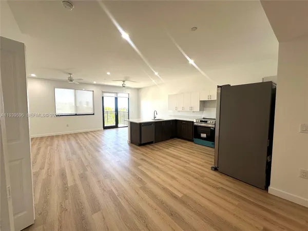 a kitchen with stainless steel appliances a refrigerator and a wooden floor