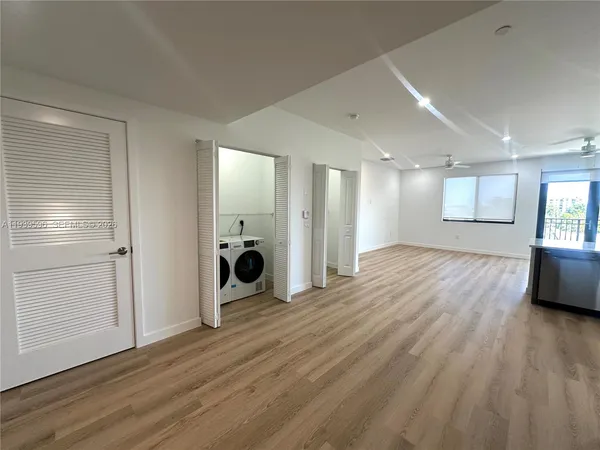 a view of a big room with wooden floor and windows