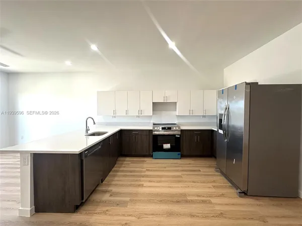 a modern kitchen with stainless steel appliances granite countertop a refrigerator and a sink