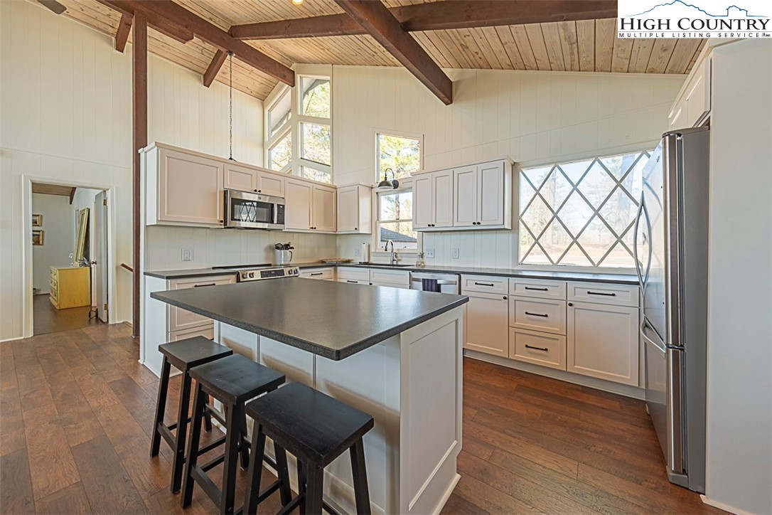 89 Rabbit Run Glade Valley, NC 28627 - Photo 10 of 32 a kitchen with a table chairs refrigerator and cabinets