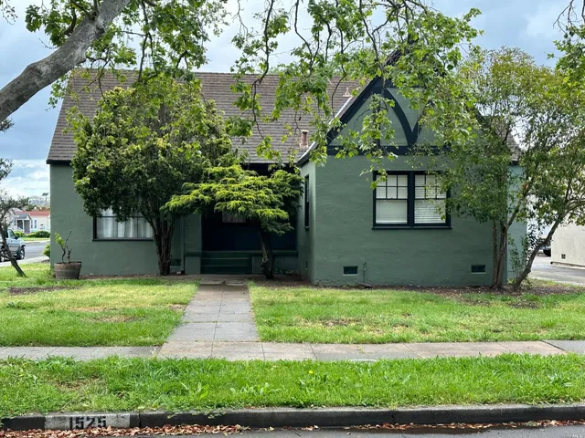 a front view of a house with yard and green space