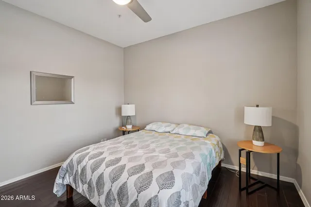 a bedroom with a bed lamps and a window