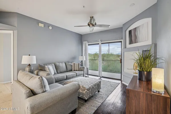 a living room with furniture large window and wooden floor