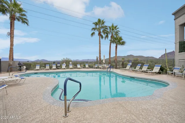 a view of a swimming pool with a lawn chairs under an umbrella