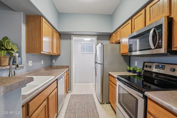 a kitchen with stainless steel appliances granite countertop a refrigerator a stove a sink and a microwave