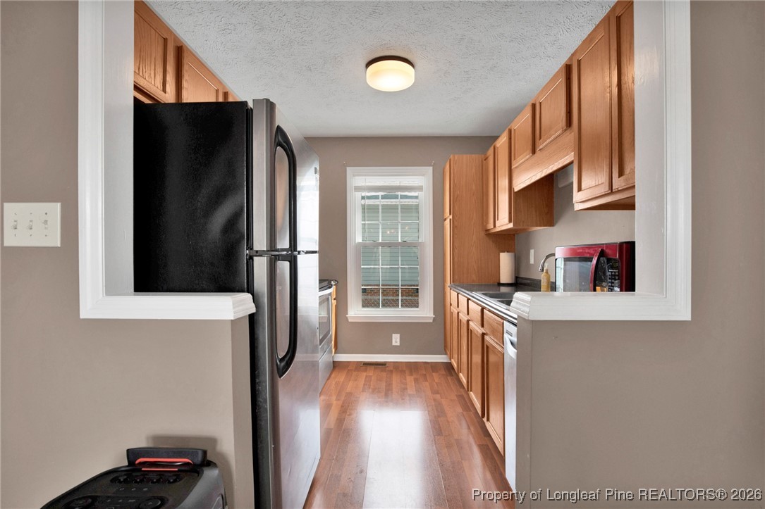3824 Constance Road Hope Mills, NC 28348 - Photo 11 of 32 a kitchen with stainless steel appliances granite countertop a refrigerator and a stove