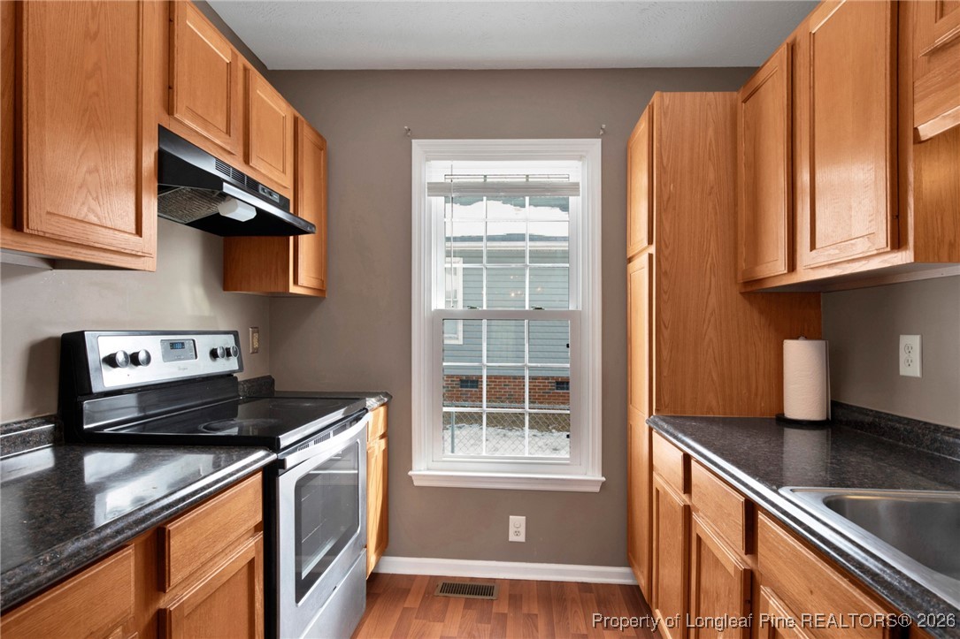 3824 Constance Road Hope Mills, NC 28348 - Photo 13 of 32 a kitchen with stainless steel appliances granite countertop a sink and a stove