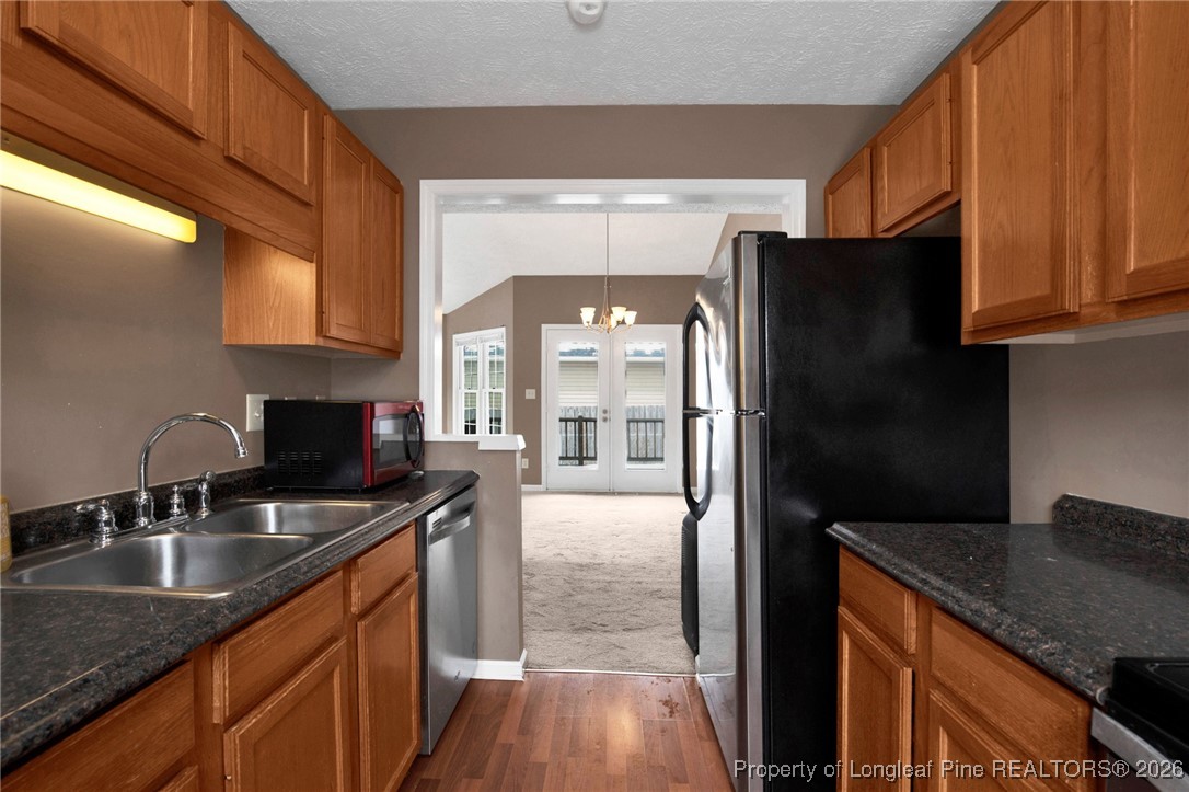 3824 Constance Road Hope Mills, NC 28348 - Photo 15 of 32 a kitchen with granite countertop a refrigerator a sink a stove and cabinets