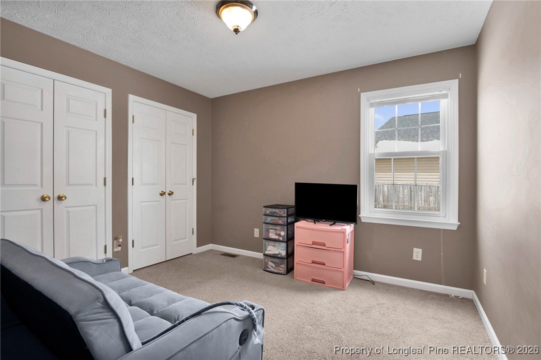 3824 Constance Road Hope Mills, NC 28348 - Photo 18 of 32 a bedroom with a bed and flat screen tv