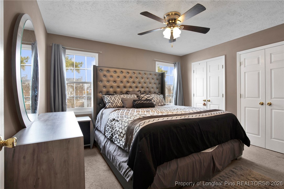 3824 Constance Road Hope Mills, NC 28348 - Photo 22 of 32 a bedroom with a bed and a chandelier