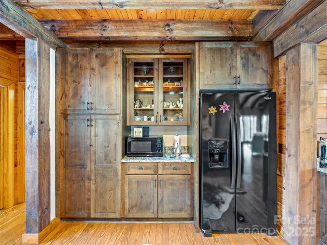 a kitchen with stainless steel appliances kitchen island granite countertop a refrigerator and a wooden cabinets