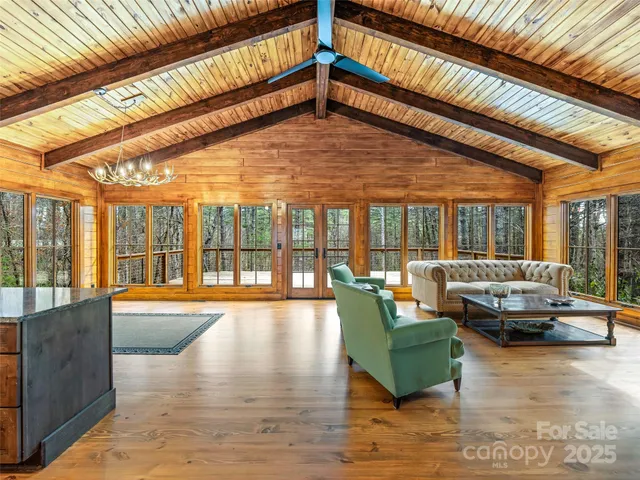 a living room with furniture floor to ceiling window and a table