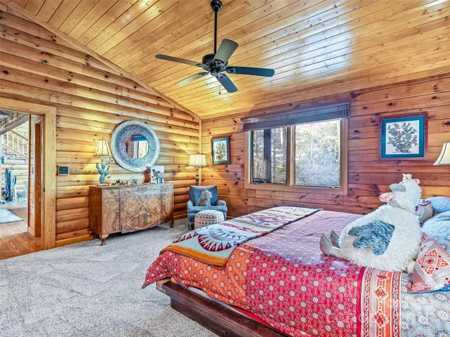 a bedroom with a bed a dresser and flat screen tv