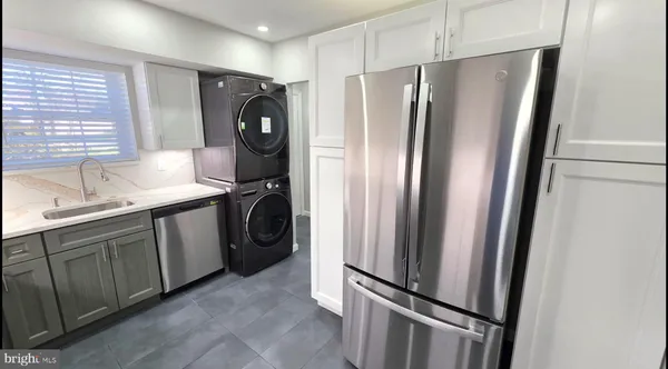 a kitchen with stainless steel appliances granite countertop a refrigerator and a sink