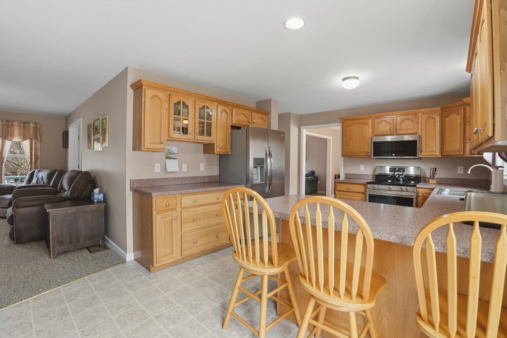 23 Bridle Path Auburn, MA 01501 - Photo 16 of 40 a kitchen with stainless steel appliances granite countertop a stove a sink dishwasher a refrigerator and cabinets with wooden floor