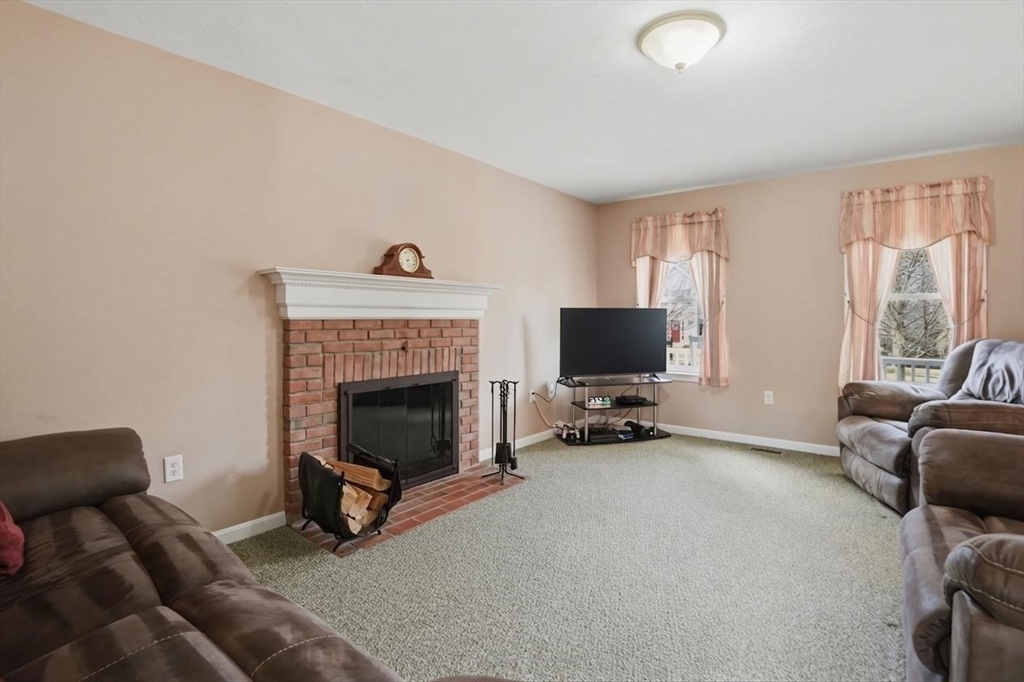 23 Bridle Path Auburn, MA 01501 - Photo 17 of 40 a living room with furniture a fireplace and a flat screen tv