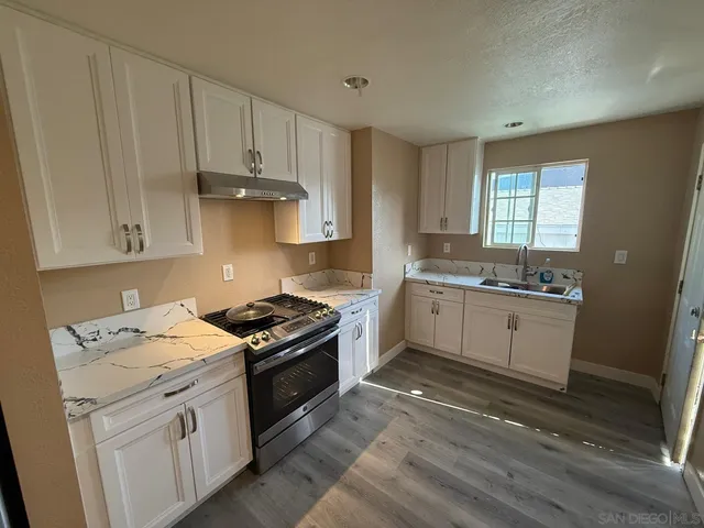 a kitchen with granite countertop white cabinets and white appliances