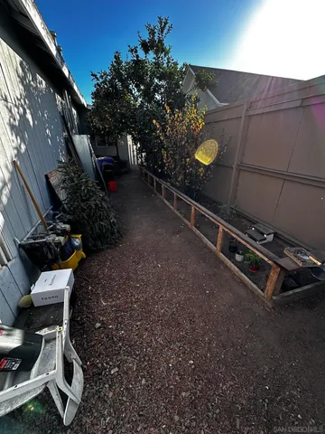 a view of a backyard with chairs and potted plants