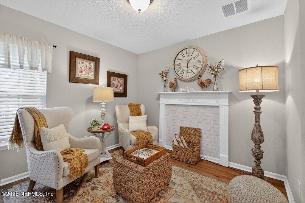 9652 Bridgeway Avenue Jacksonville, FL 32222 - Photo 5 of 35 a living room with furniture a clock and a fireplace