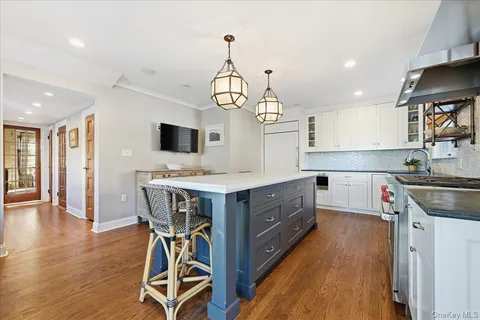 a kitchen with stainless steel appliances granite countertop a kitchen island hardwood floor and a sink